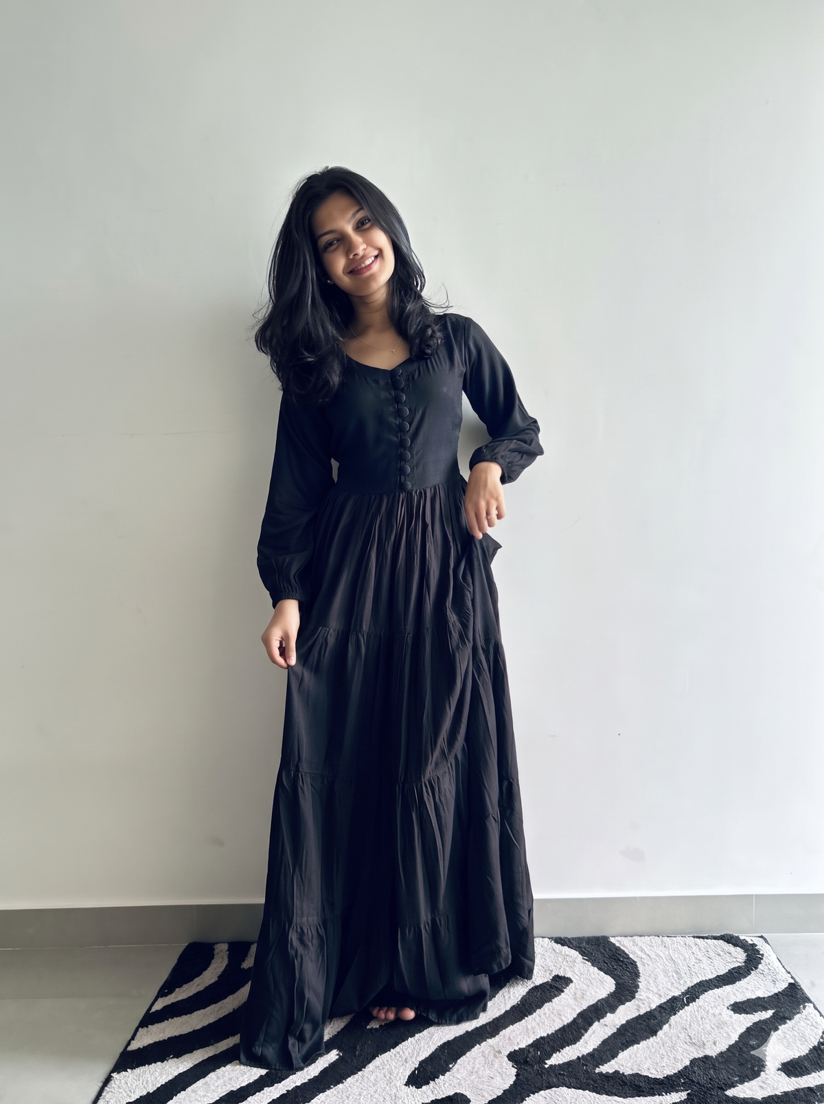 Black full sleeve tiered maxi dress for women in soft flowy rayon, showing covered buttons and flared tiered skirt – Vastramaniaa