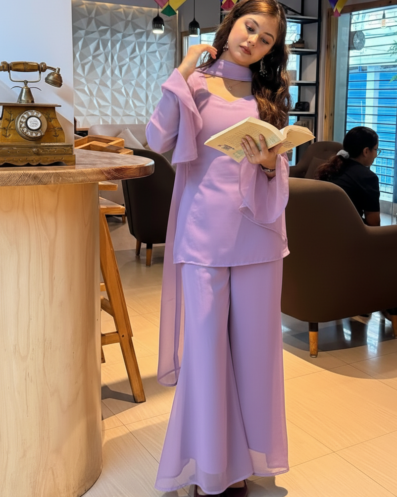 Woman in a lavender outfit reading a book in a cafe.