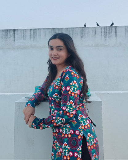 Woman in a floral dress standing on a rooftop with a plain background
