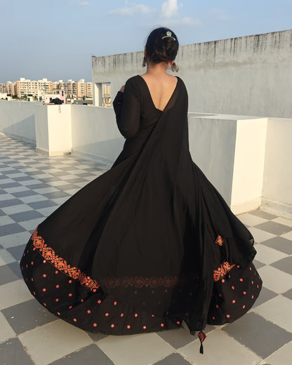 Close-up of embroidered detailing on sleeves of black rayon Anarkali dress with V-neck.