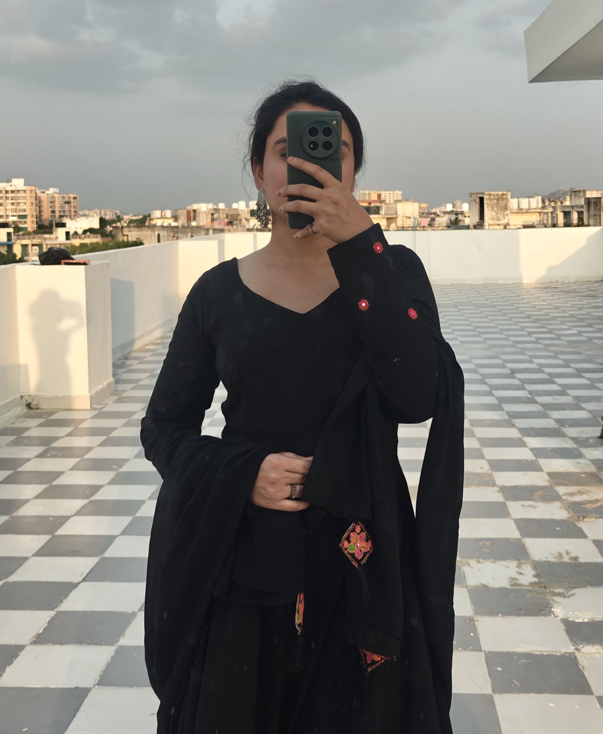 selfiPose Close-up of embroidered detailing on sleeves of black rayon Anarkali dress with V-neck.