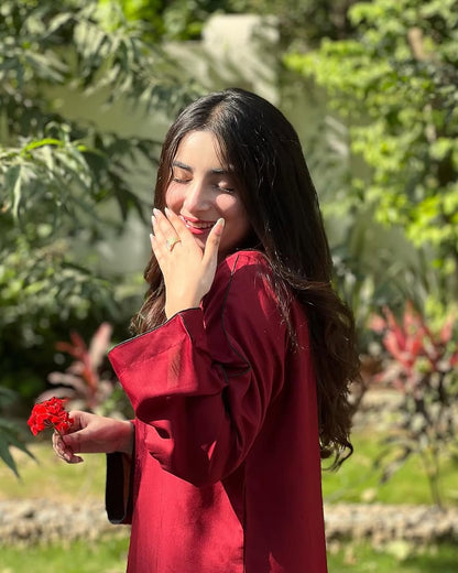 Woman in a red outfit holding flowers in a garden