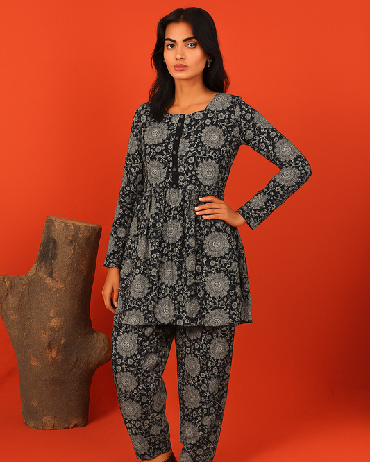 Woman wearing a black floral outfit against an orange background