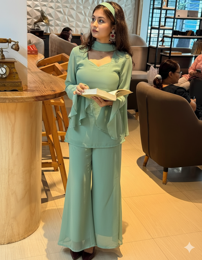 Woman in a light green outfit holding a book in a cafe setting