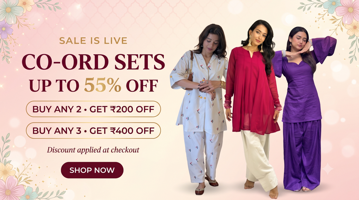 Promotional banner for women's co-ord sets showing three models wearing matching traditional outfits in white, red, and purple, alongside sale text and discount offers on a soft pink floral background.