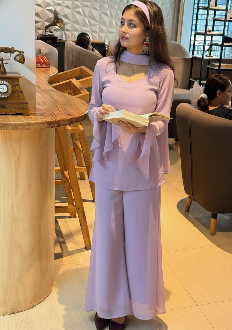 Woman in a lavender outfit holding a book in a cafe setting