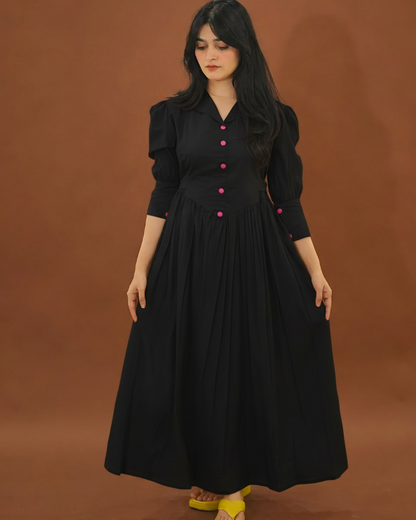 Woman wearing a black dress with pink buttons against a brown background