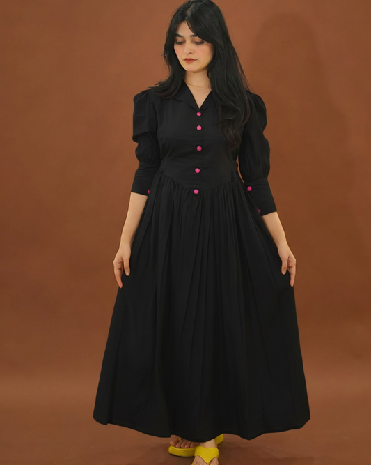 Woman wearing a black dress with pink buttons against a brown background