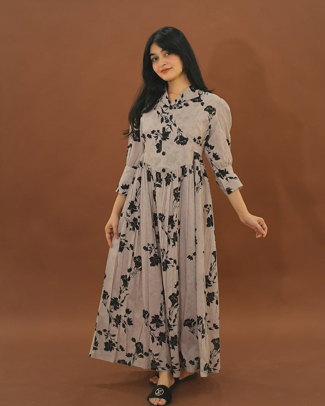 Woman wearing a floral dress against a brown background