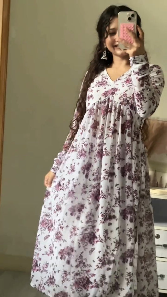 Woman wearing a white dress with purple floral patterns, taking a mirror selfie.